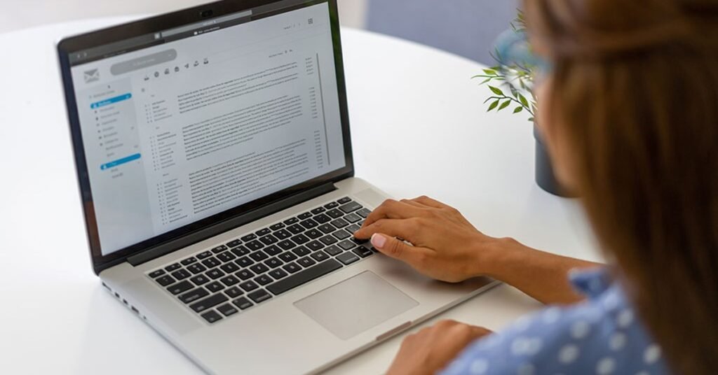 Writing outreach email on laptop